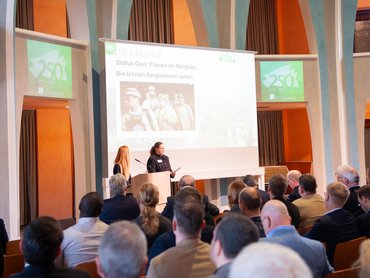 Zuschauende blicken nach vorne zur Rednerin