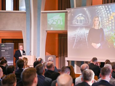 Zuschauer blicken nach vorne auf eine Leinwand